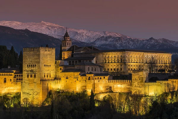 View at dusk of Alhambra palace with the snowy Sierra Nevada in the background, Granada