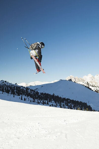 a view of a freestyler flying with his skis after a jump in Val Gardena, Bolzano province