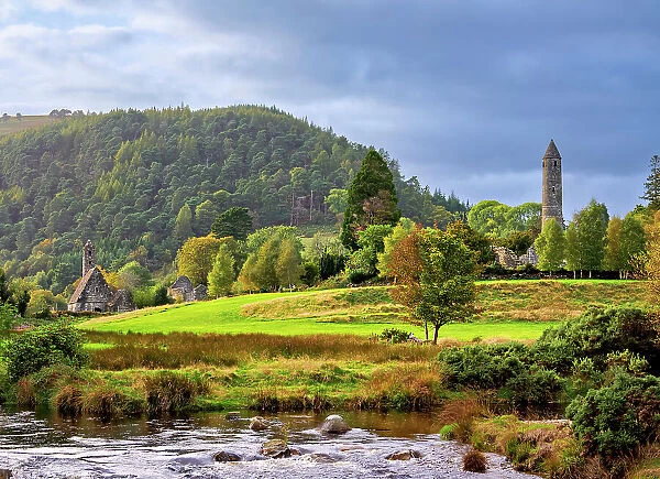 View over Glendasan River towards St. Kevin's Church and The Round Tower at sunset, Early Medieval Monastic Settlement, Glendalough, County Wicklow, Ireland