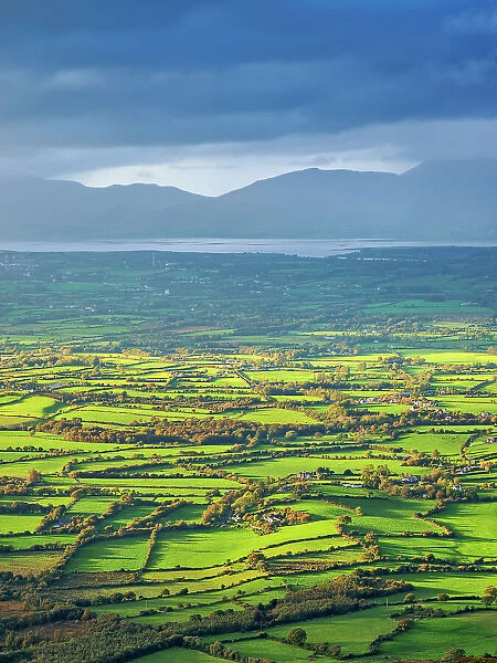 View over the green fields towards the Atlantic Coast from the top of the Strickeen Mountain, Ballagh, County Kerry, Ireland