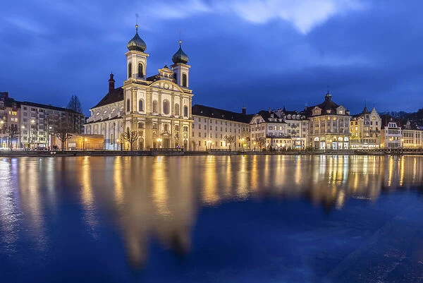 View of the Jesuit Church and the old town of Lucerne at blue hour reflected on the Reuss