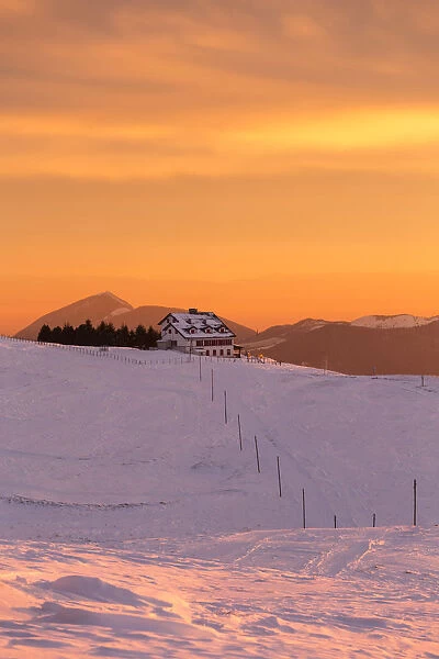 View of the Magnolini refuge during a winter sunset from Monte Pora, Val Seriana