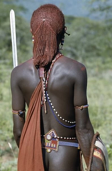 A back view of a Msai warrior resplendent with long