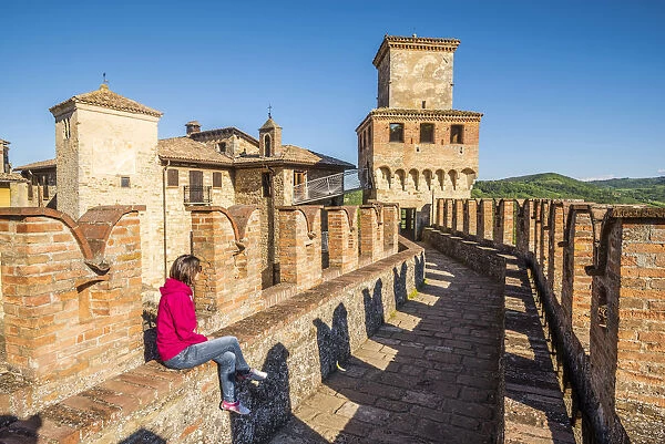 Vigoleno, Piacenza, Emiglia-Romagna, Italy. Woman sitting on the castle walls