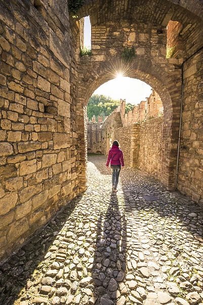 Vigoleno, Piacenza, Emiglia-Romagna, Italy. Woman walking inside the castle walls