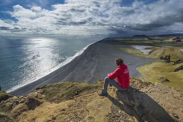 Vik, Southern Iceland. Man looks the horizon on top of Dyrholaey