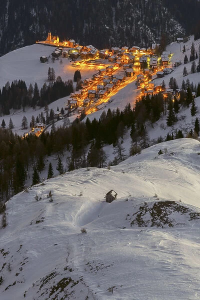The village of Colle Santa Lucia, seen from above on a cold winter evening, Belluno