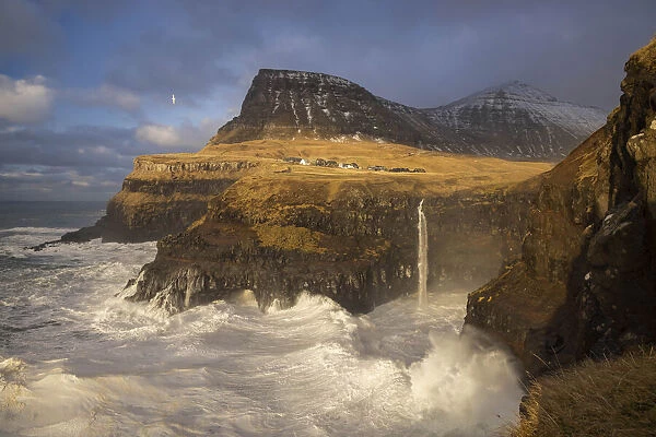 The village of Gasadalur and its waterfal hit by a storm. Island of Vagar. Faroe Islands