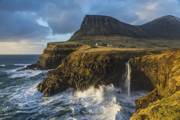 Framed Print : The village of Gasadalur and its waterfall, at sunset, while they are hit by strong winds. Vagar, Faroe Islands