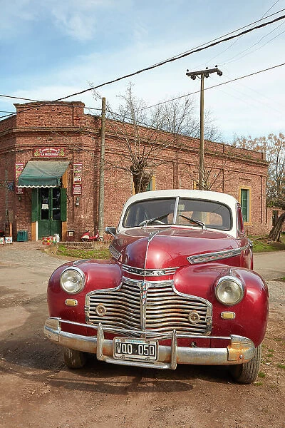 A vintage Chrysler car in front of a historical building of the Uribelarrea town, Buenos Aires province, Argentina