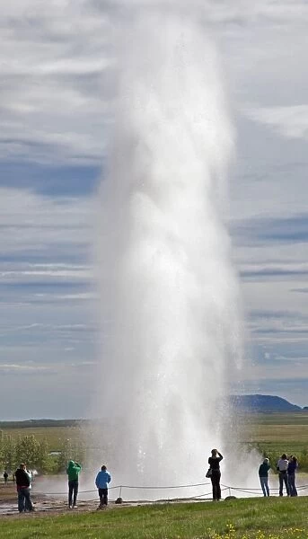 Visitors watching the famous Strokkur geyser which erupts every 8 to 10 minutes, thrusting hot water and steam 25 to 35 metres into the air. Only Yellowstones Old Faithful is larger albeit with less frequent activity