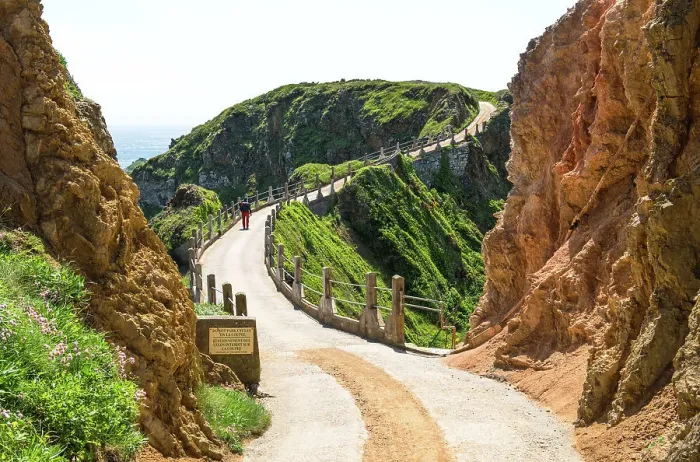 Framed Print : A walker crossing La Coupee, an isthmus joining Great Sark and Little Sark, three metres wide and with a drop of 80 metres on either side, Isle of Sark, Channel Islands (MR) Framed Print : A walker crossing La Coupee, an isthmus joining Great Sark and Little Sark, three metres wide and with a drop of 80 metres on either side, Isle of Sark, Channel Islands (MR)