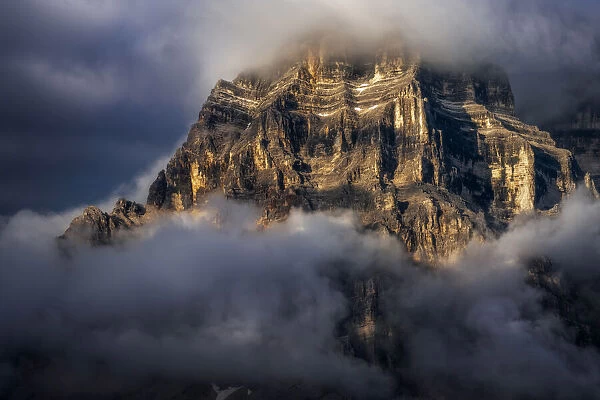 The walls of Mt. Pelmo in the Italian Dolomites hit by the golden light during a clearing storm in summer