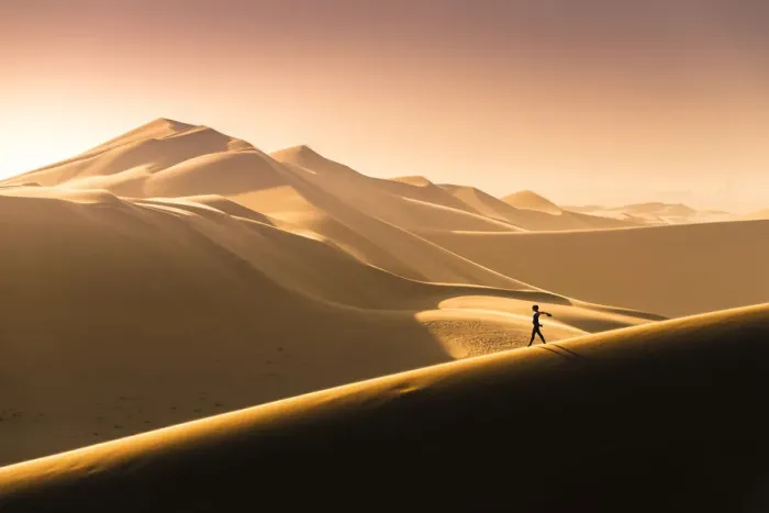 Framed Print : Walvis Bay, Namibia, Africa. Tourist walking on the sand dunes at sunset