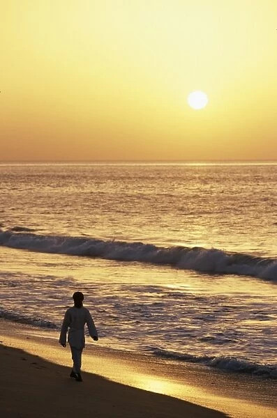 A warden walks along the beach at Ras al Jinz at sunrise