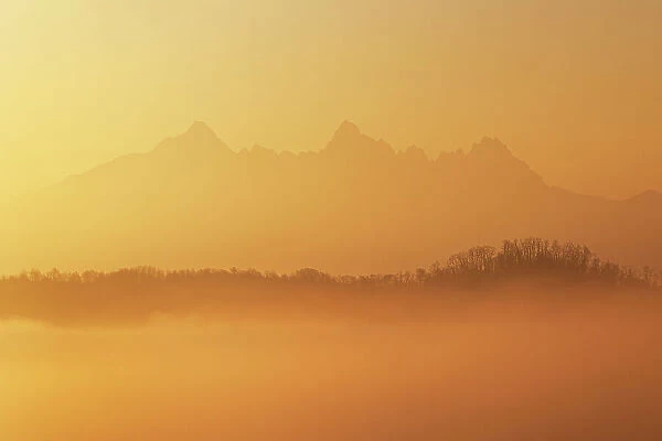 the warm light envelope the Apuan Alps during a winter sunrise, Tuscany, Italy
