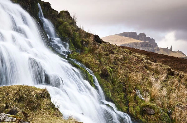 A waterfall with the Old Man of Storr in the background, Isle of Skye, Scotland, UK