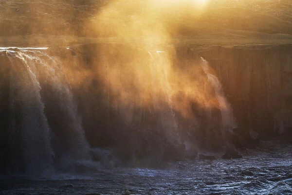 Waterfall spray hit by the golden light of sunset, Selfoss, Iceland