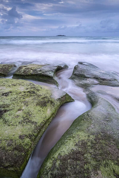 Waves wash over sandstone ledges at Harlyn Beach in Cornwall, England. Spring (May) 2021