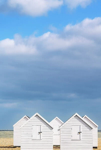 White beach huts ion a beach in Walmer, Kent, England