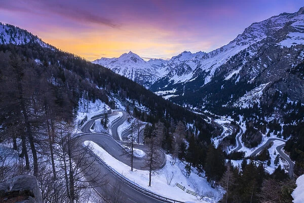 The winding curves of Maloja Pass road in winter at sunset, Bregaglia Valley, canton of Graubünden, Engadin, Switzerland