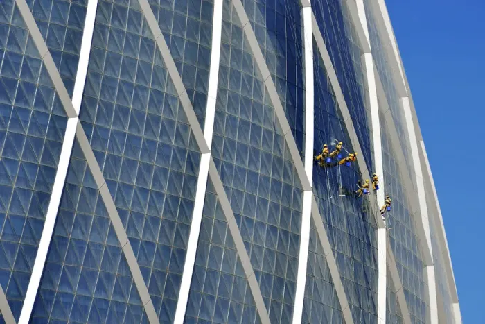 Framed Print : Window cleaners hanging on The Coin building Aldar headquarters, one of the largest