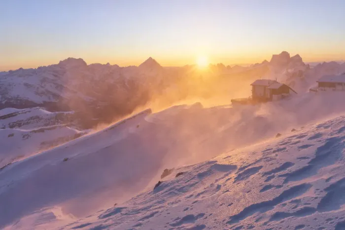 Framed Print : a windstorm lifts the snow in a cold winter sunrise at the Lagazuoi refuge