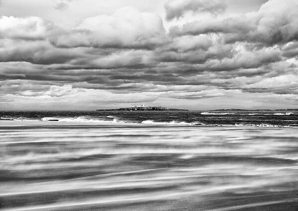 Windy day on a sandy beach between Bamburgh and Seahouses, with the Farne islands in the background