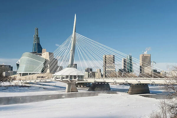 Winnipeg skyline with the Canadian Museum for Human Rights (CMHR) and the Esplanade Riel Bridge and the Red River in winter, Winnipeg, Manitoba, Canada