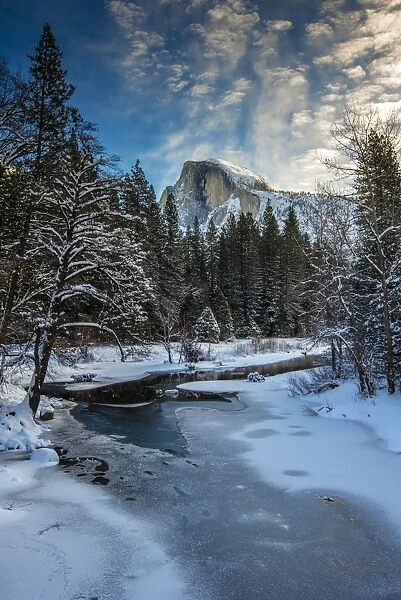 Winter view over icy Tenaya creek with Half Dome mountain behind, Yosemite National Park