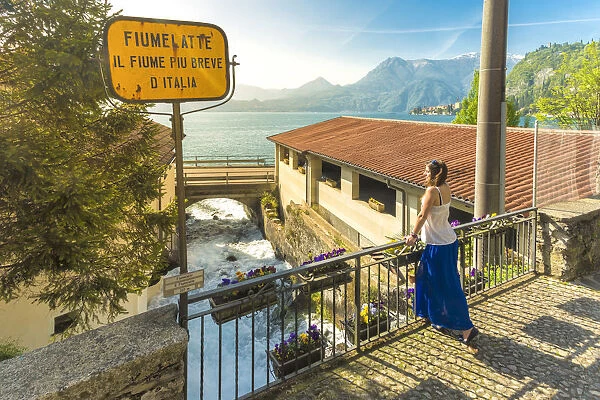 Woman admiring the short Fiumelatte river, Lake Como, Varenna, lecco Province, Lombardy
