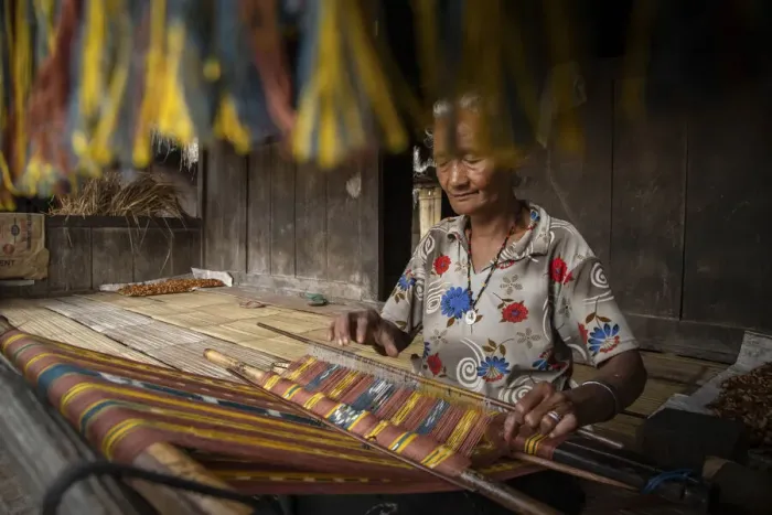 Framed Print : A woman in Bena village making woven fabrics called Tenun Ikat. Flores Island