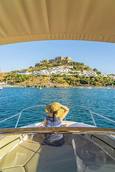A woman on a boat looking at the Acropolis of Lindos, Lindos, Rhodes, Dodecanese Islands, Greece. (MR)