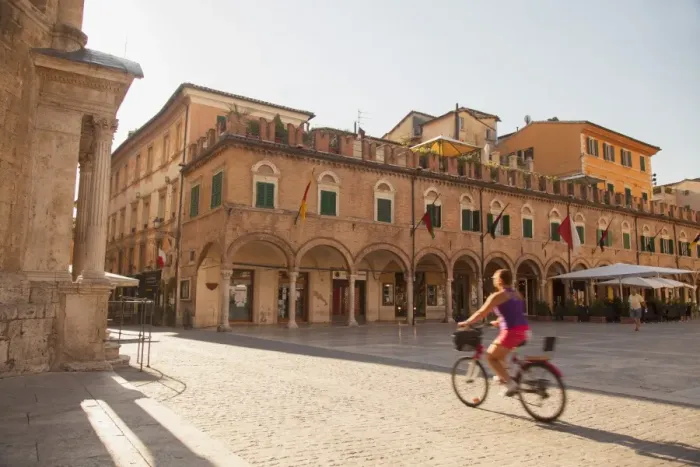 Framed Print : Woman cycling through Piazza del Popolo, Ascoli Piceno, Le Marche, Italy Framed Print : Woman cycling through Piazza del Popolo, Ascoli Piceno, Le Marche, Italy