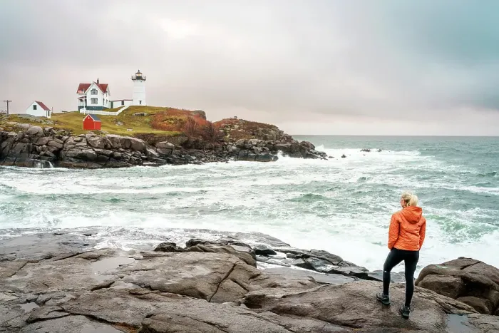 Framed Print : Woman enjoying the view of Cape Neddick Lighthouse also called Nubble Lighthouse, York, Maine, New England, USA