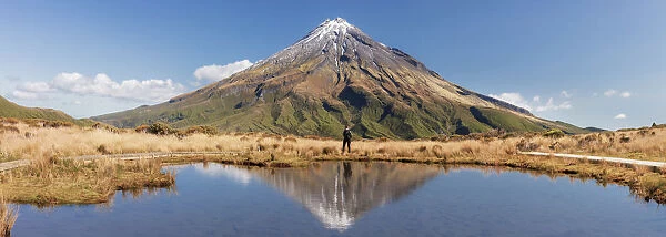A woman enjoying the view of the Taranaki volcano in New Zealand northern island