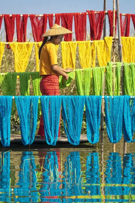 Framed Print : Woman hanging dyed yarn from a boat to dry in a traditional weaving village on Lake Inle Framed Print : Woman hanging dyed yarn from a boat to dry in a traditional weaving village on Lake Inle