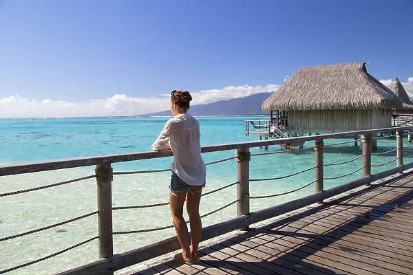 Woman on jetty of overwater bungalows of Sofitel Hotel, Moorea, Society Islands, French