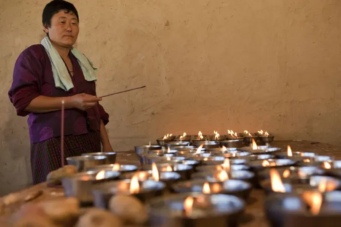 Framed Print : A woman lighting butter candles in Ura in the Bumthang Valley of Bhutan Framed Print : A woman lighting butter candles in Ura in the Bumthang Valley of Bhutan