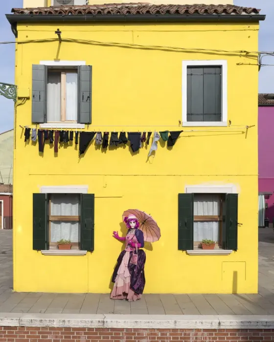 Framed Print : Woman in pink costume holding umbrella in front of yellow house during Carnival, Island Framed Print : Woman in pink costume holding umbrella in front of yellow house during Carnival, Island