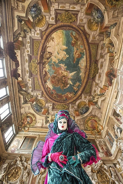 A woman poses in costume during the Venice Carnival inside an ornate palace