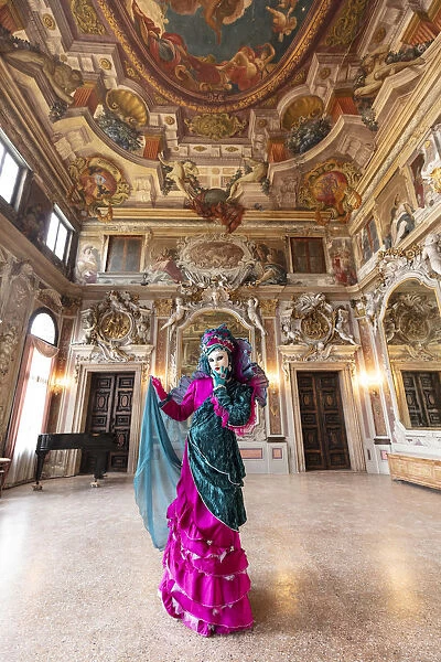 A woman poses in costume during the Venice Carnival inside an ornate palace