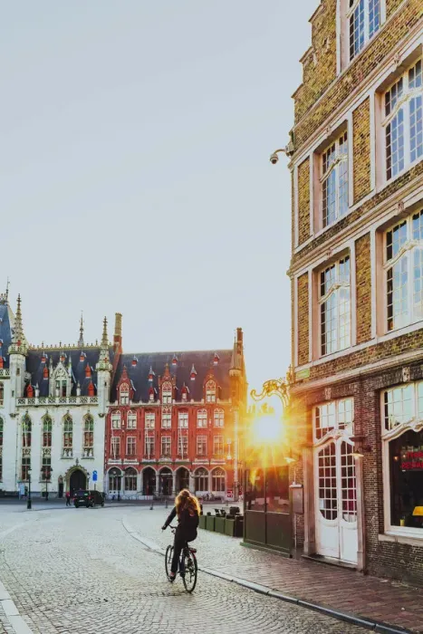 Framed Print : A woman riding a bike in Bruges Market Square at sunrise, Belgium Framed Print : A woman riding a bike in Bruges Market Square at sunrise, Belgium