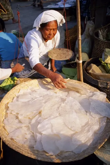 Framed Print : A woman sells rice pancakes from her stall at a street market