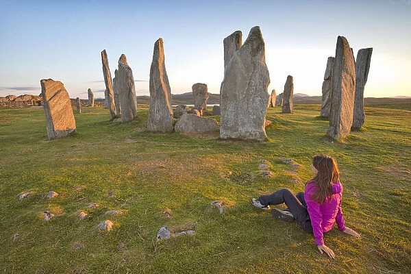 Woman staring at Neolithic stone circle, Callanish, Isle of Lewis, western scotland