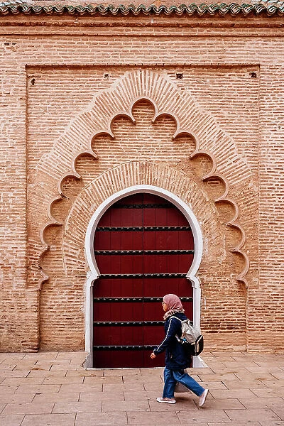 Woman student and typical arab door, Marrakech, Morocco