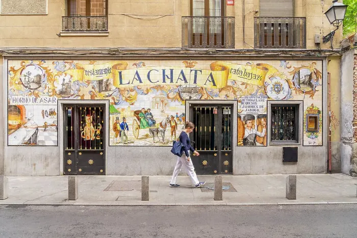 Framed Print : A woman walking past La Chata Restaurant, Madrid, Spain Framed Print : A woman walking past La Chata Restaurant, Madrid, Spain