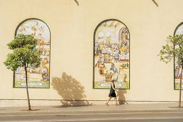 A woman walking past the Museum of the Brotherhood of Hope, Malaga, City, Andalusia, Spain. MR
