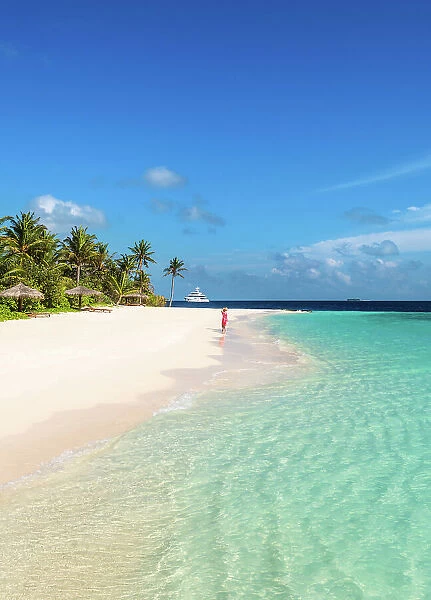 Woman walking on a sandy beach, Baa Atoll, Maldives