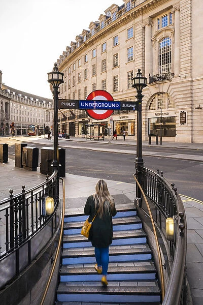 Woman walking out the tube on to Regents Street, london, England, UK